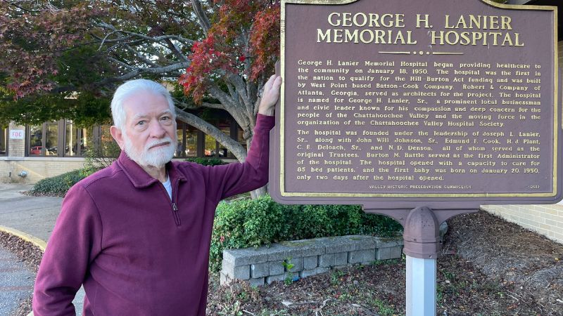 Billy Joe Stewart, the first baby born at Lanier Memorial Hospital in Valley, Alabama, posed for a photo in front of the building.