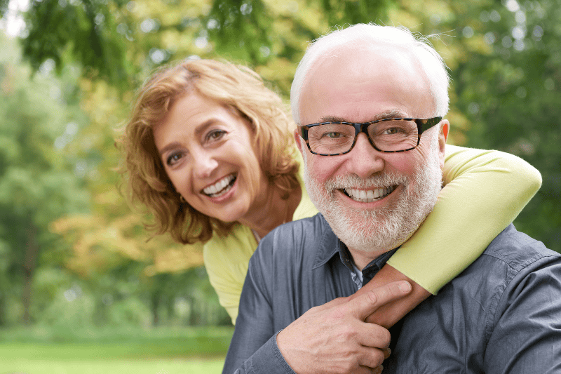 woman and man with glasses smiling