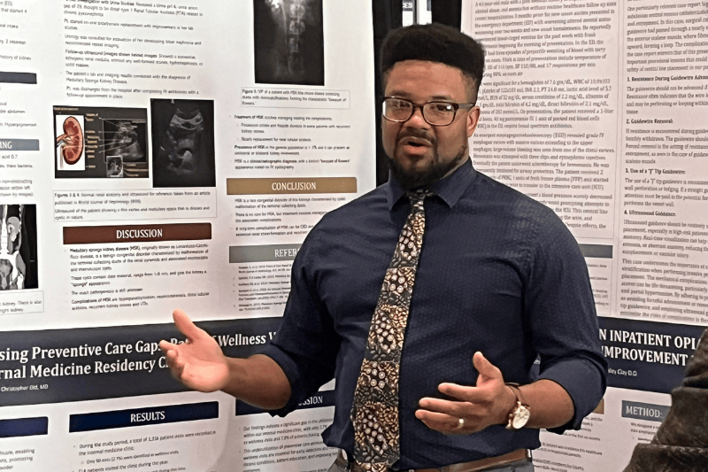 A resident displaying a poster presentation.