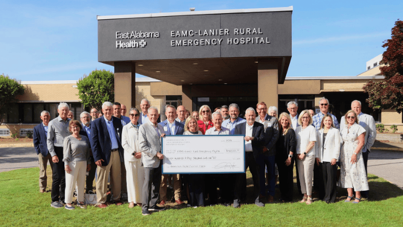 East Alabama Health officials and community members pose for a photo outside of EAMC-Lanier Rural Emergency Hospital with a check.
