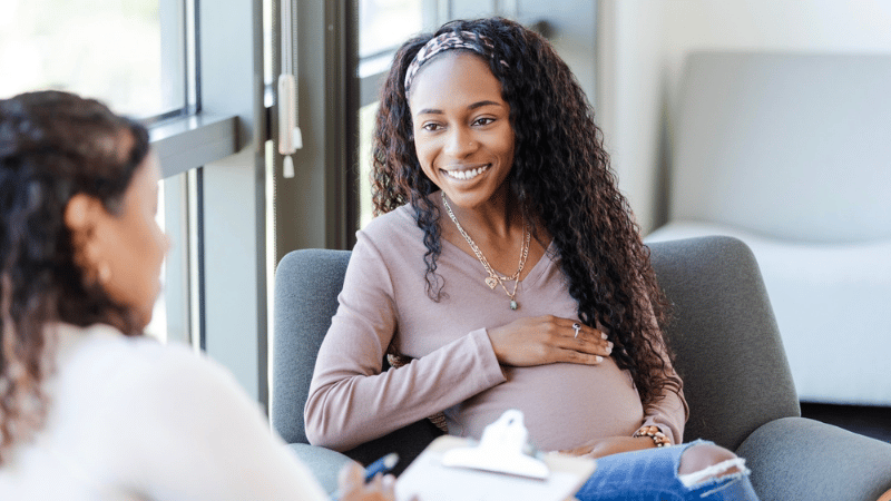 A pregnant patient speaking with a physician