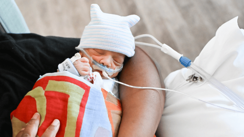 A baby in a LovEvolve Swaddle blanket at EAMC. 