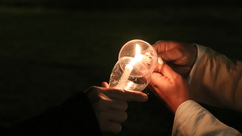 Attendees at a Wave of Light ceremony lighting candles of remembrance.