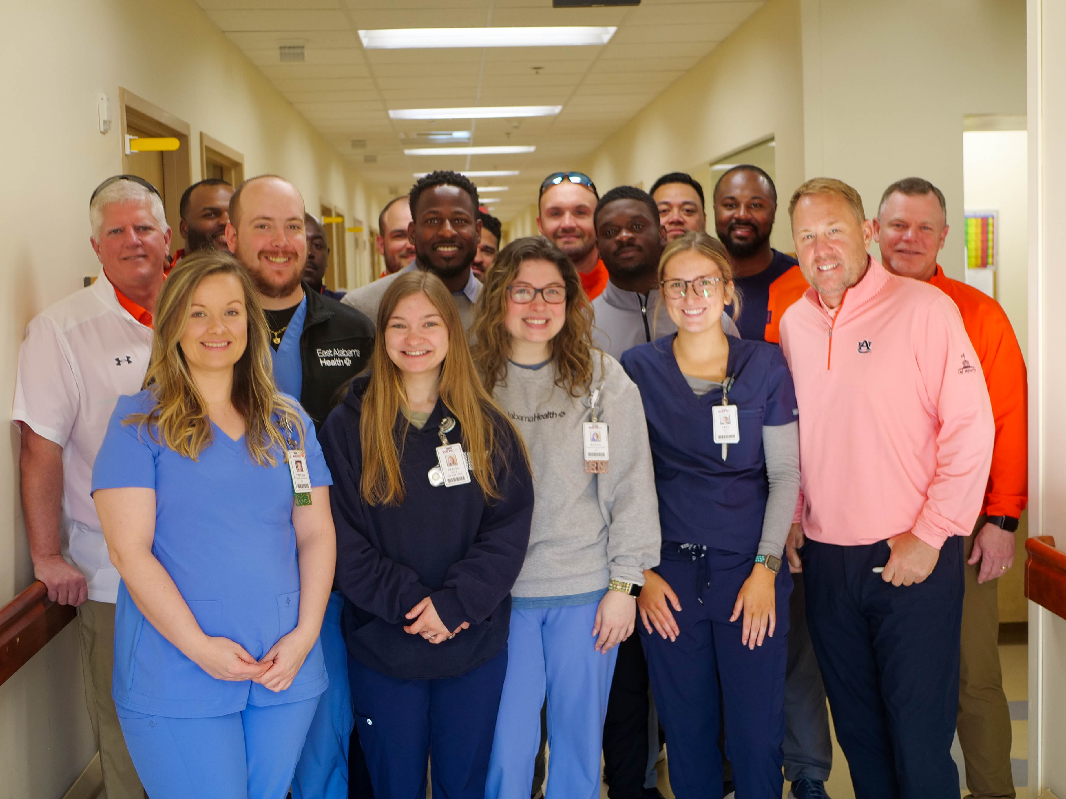 Auburn Football Coaches take photo with fifth floor staff at EAMC.